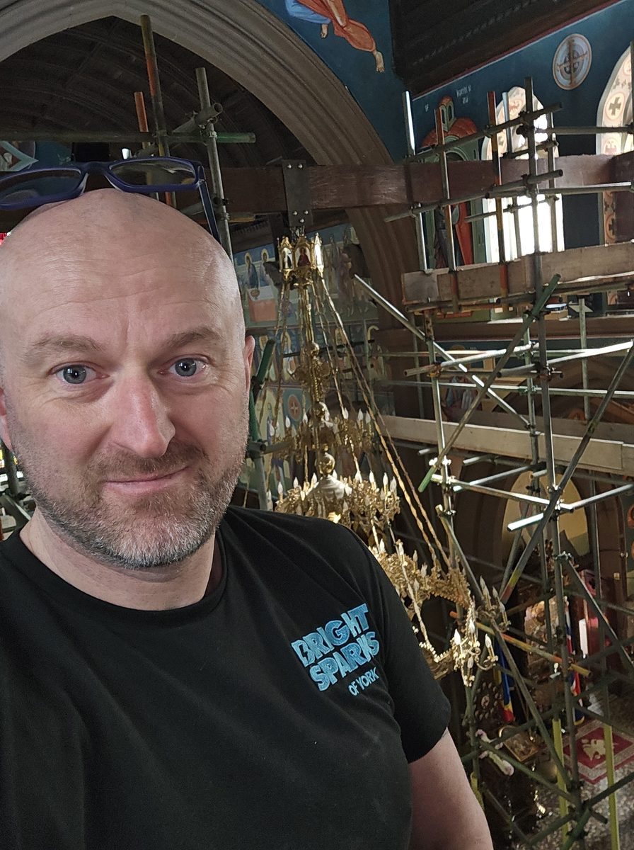 Frankie from Bright Sparks of York on scaffolding inside the church